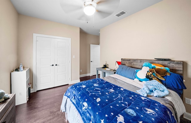 bedroom with dark wood-type flooring, ceiling fan, and a closet