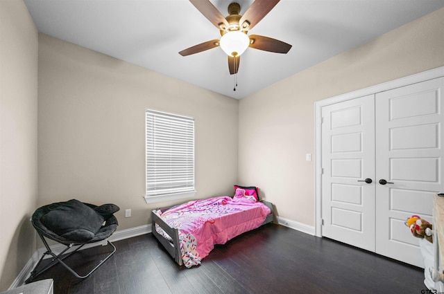 bedroom with dark hardwood / wood-style flooring, ceiling fan, and a closet