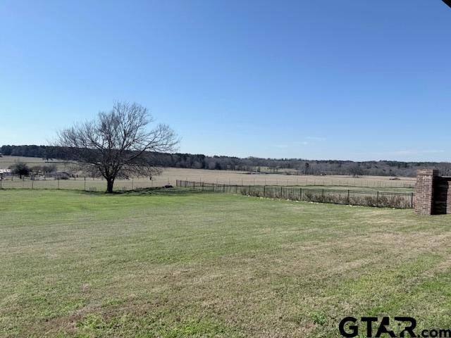 view of yard with a rural view and fence