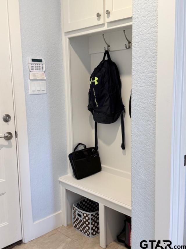 mudroom with light tile patterned floors and a textured wall