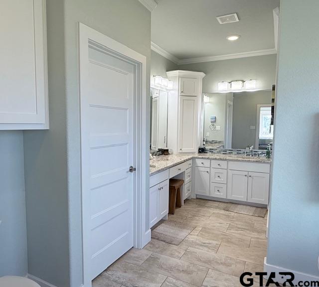 bathroom with recessed lighting, a sink, visible vents, ornamental molding, and double vanity