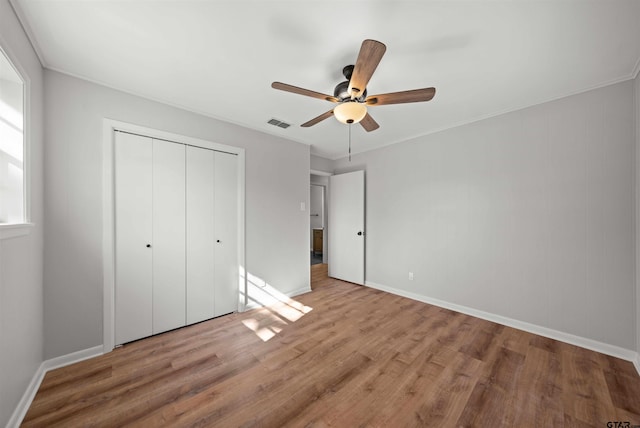 unfurnished bedroom with hardwood / wood-style floors, a closet, and ceiling fan