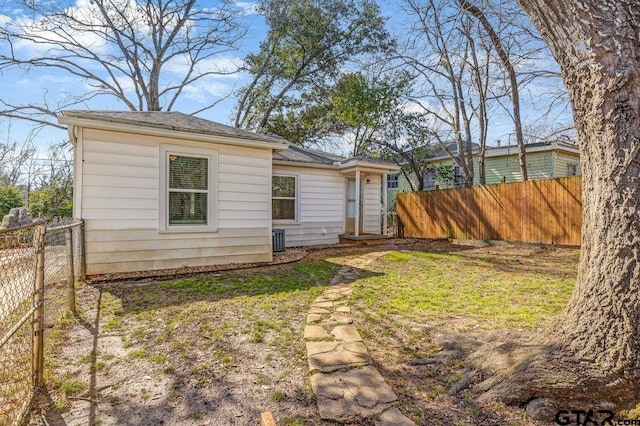 exterior space featuring fence, central AC, and a yard