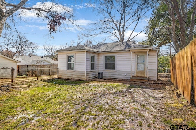 back of property with entry steps, a yard, cooling unit, and a fenced backyard