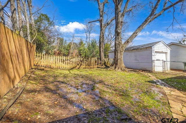 view of yard with a garage, a storage shed, an outdoor structure, and a fenced backyard