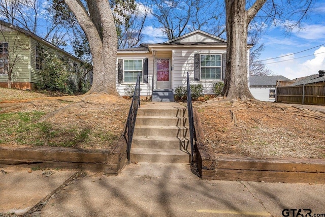 bungalow-style home featuring fence