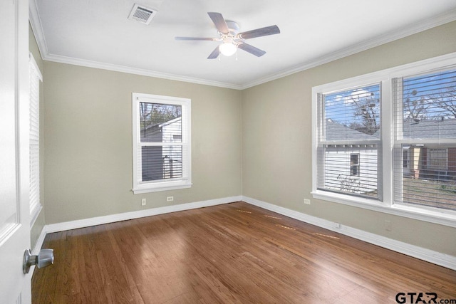 empty room featuring baseboards, visible vents, dark wood-style floors, ceiling fan, and ornamental molding