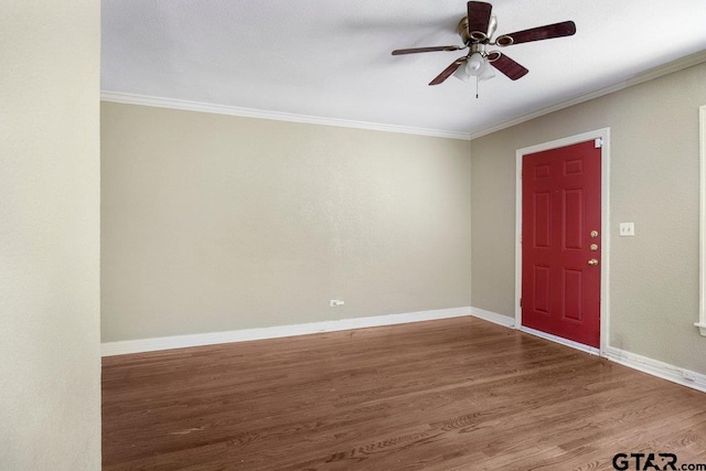 foyer entrance featuring ornamental molding, a ceiling fan, baseboards, and wood finished floors