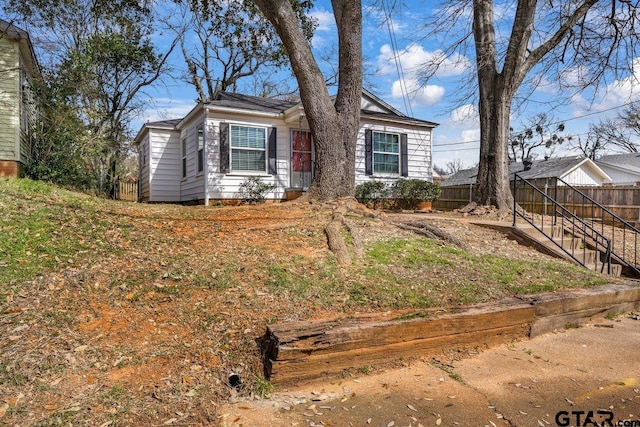 view of front of home featuring fence and stairs