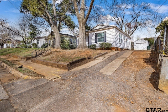 view of front of home featuring a garage, driveway, and an outdoor structure