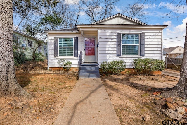 bungalow-style home with fence