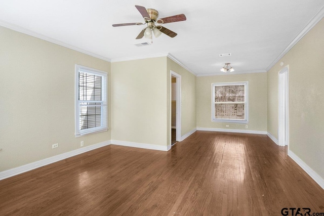 unfurnished room with crown molding, visible vents, dark wood finished floors, and baseboards