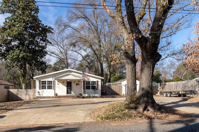 view of front facade featuring driveway and fence