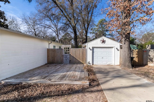 exterior space featuring an outbuilding, a gate, fence, a garage, and driveway