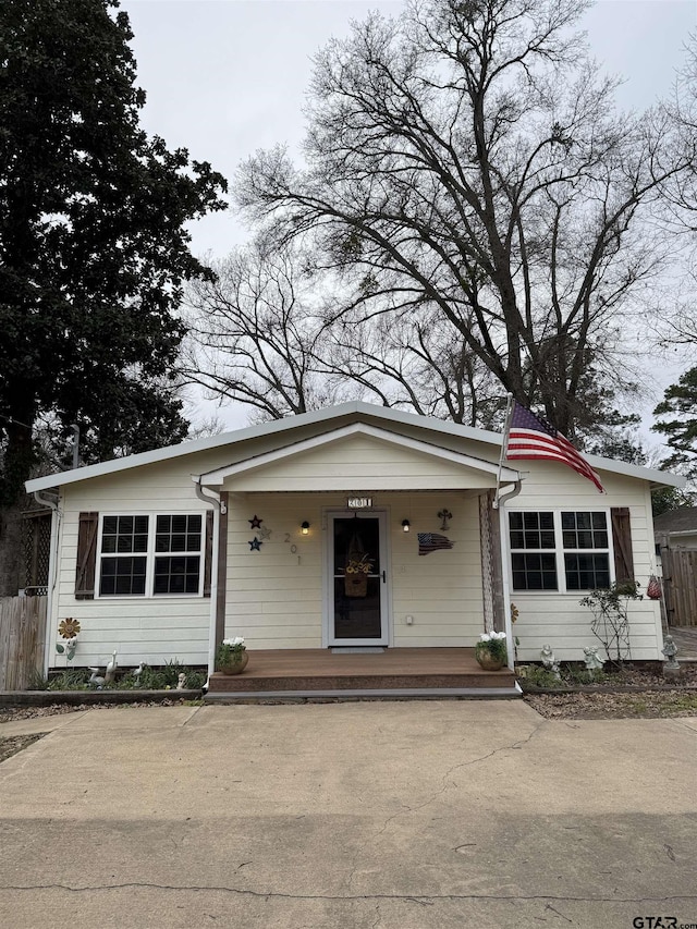 bungalow-style house with covered porch and fence