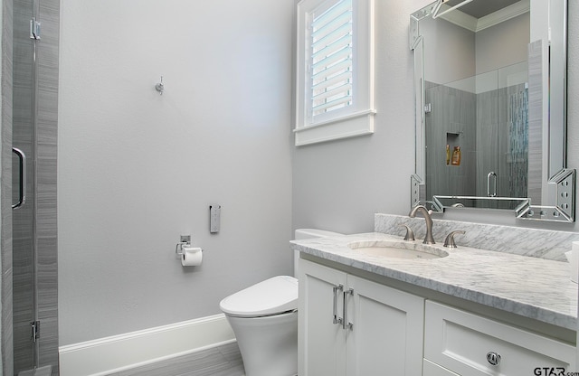 bathroom featuring vanity, toilet, and an enclosed shower