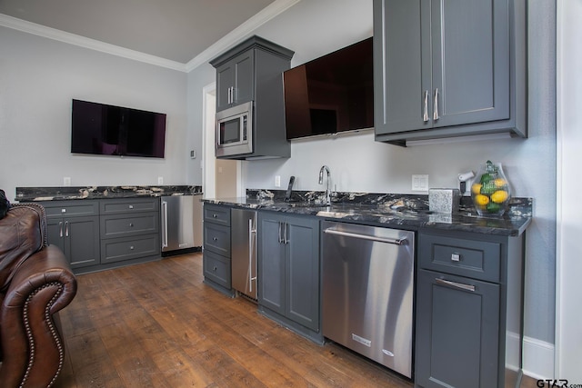 kitchen with sink, appliances with stainless steel finishes, ornamental molding, dark hardwood / wood-style floors, and gray cabinets