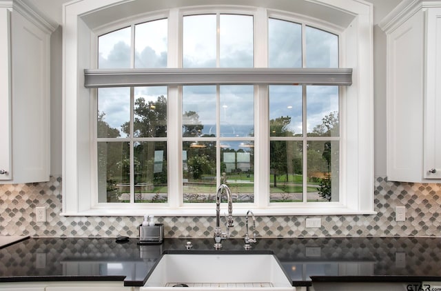 room details with white cabinetry, sink, and decorative backsplash