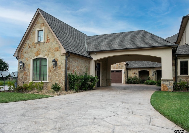 view of front facade featuring a front lawn, a garage, and a carport