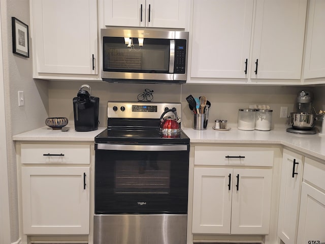 kitchen featuring white cabinets, stainless steel appliances, and light countertops