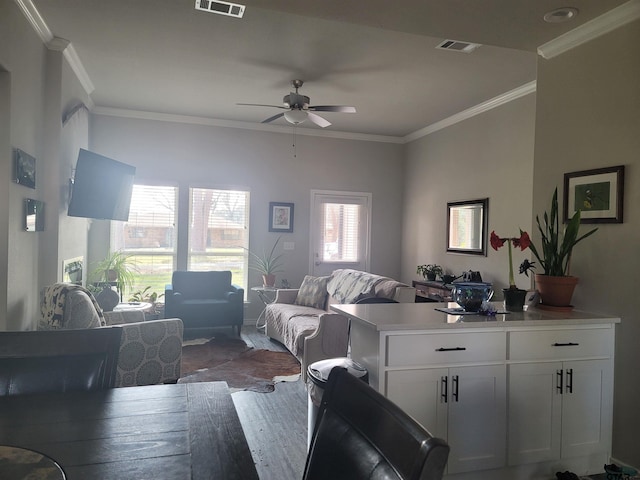 living room with hardwood / wood-style flooring, crown molding, and ceiling fan