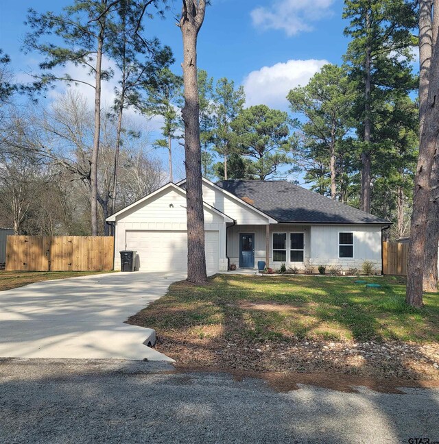 single story home featuring a garage and a front yard