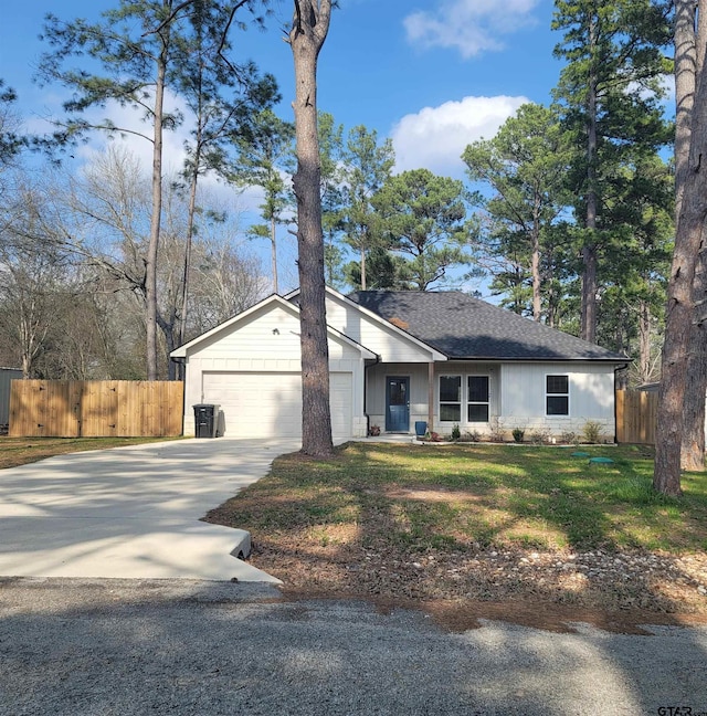 view of front of house with driveway, a garage, fence, and a front lawn