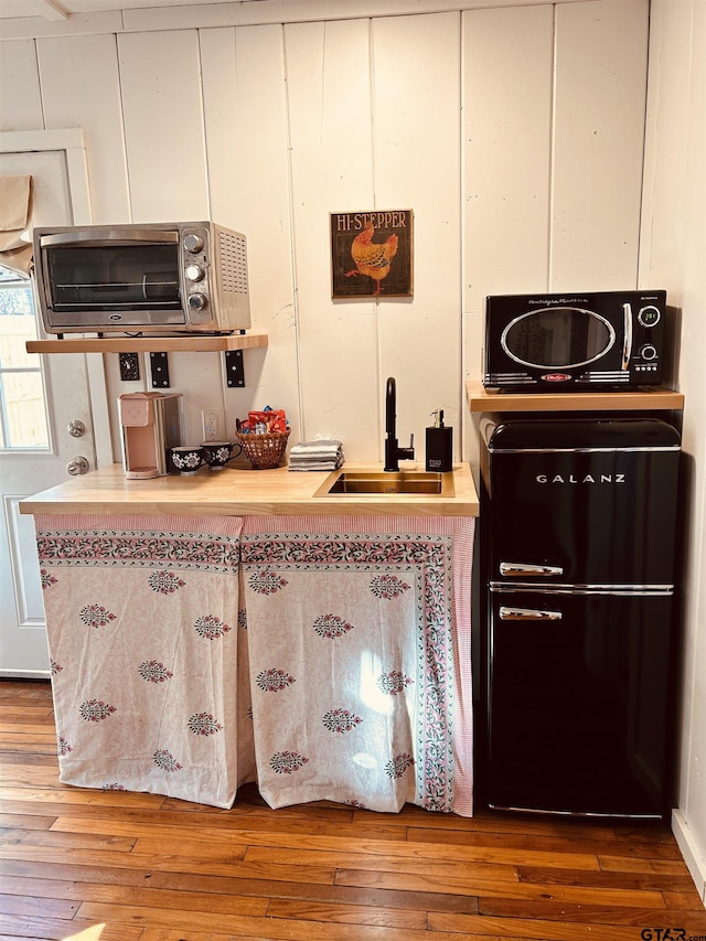 kitchen with hardwood / wood-style flooring and sink