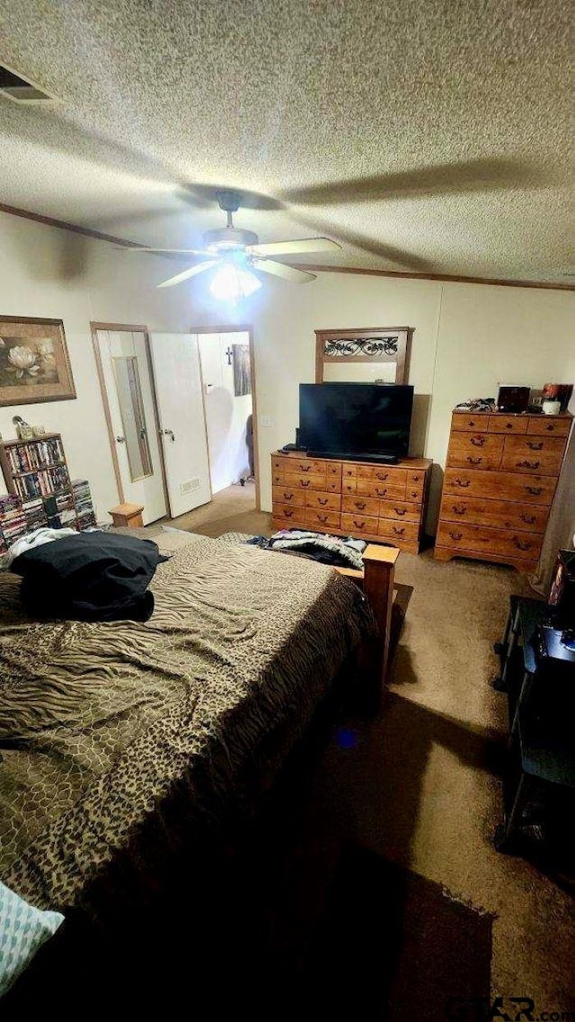 carpeted bedroom with ceiling fan and a textured ceiling