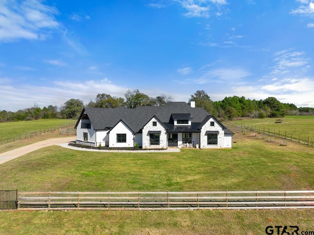 view of front of house with a rural view and a front yard