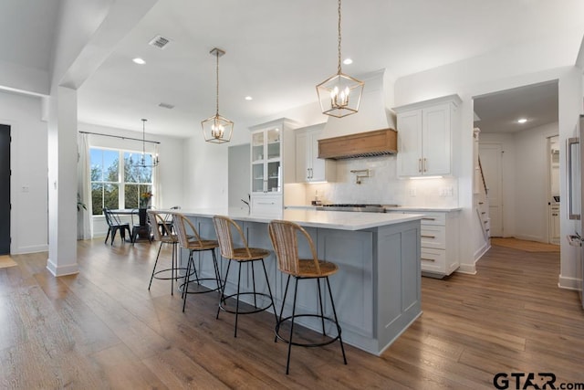 kitchen featuring white cabinets, hardwood / wood-style floors, and pendant lighting