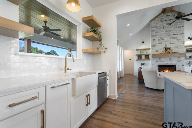 kitchen featuring dark wood-type flooring, sink, dishwasher, white cabinets, and vaulted ceiling with beams