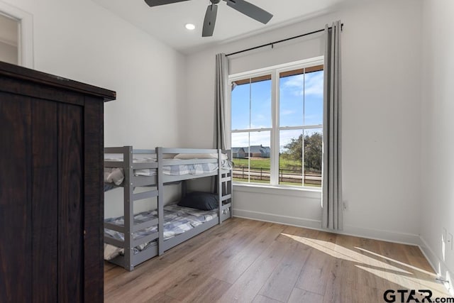 bedroom with light hardwood / wood-style floors, multiple windows, and ceiling fan