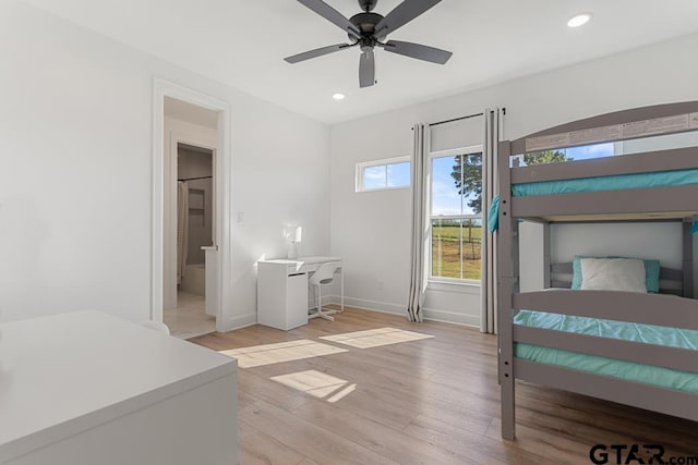 bedroom featuring ceiling fan, light wood-type flooring, and ensuite bathroom