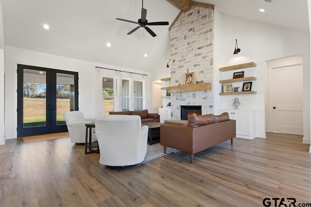 living room featuring french doors, a fireplace, high vaulted ceiling, beamed ceiling, and hardwood / wood-style floors