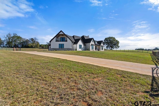 view of front of home featuring a front yard and a rural view