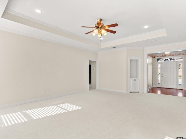 unfurnished room featuring crown molding, carpet, and a tray ceiling