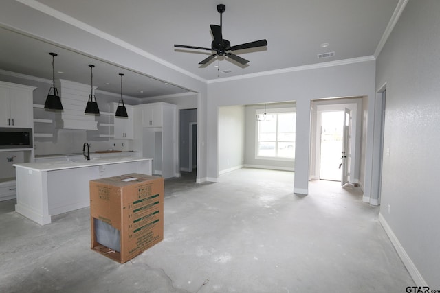 kitchen featuring white cabinets, sink, crown molding, and a center island