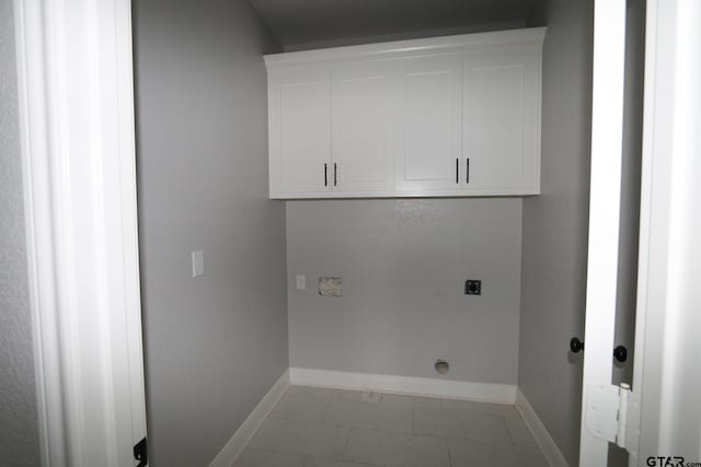 laundry area with cabinets, light tile patterned floors, and electric dryer hookup