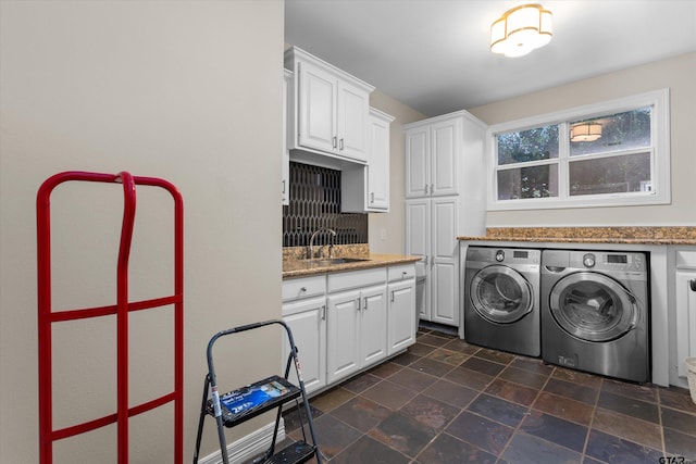 laundry area with cabinets, washing machine and dryer, and sink