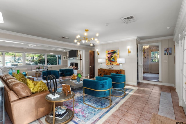 living room featuring a brick fireplace, ornamental molding, light tile patterned floors, and a chandelier