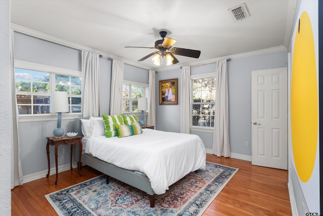 bedroom featuring ceiling fan, crown molding, and hardwood / wood-style flooring