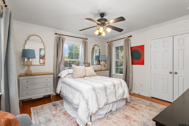 bedroom with hardwood / wood-style floors, ceiling fan, crown molding, and a closet