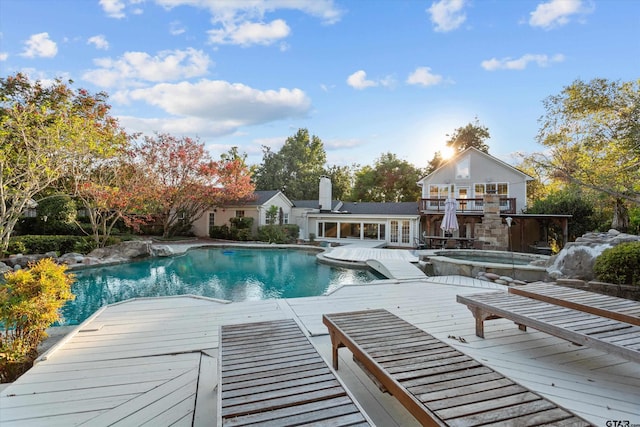 view of pool with an in ground hot tub and a wooden deck