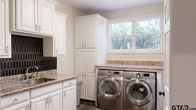 laundry area with cabinets, independent washer and dryer, dark tile patterned floors, and sink