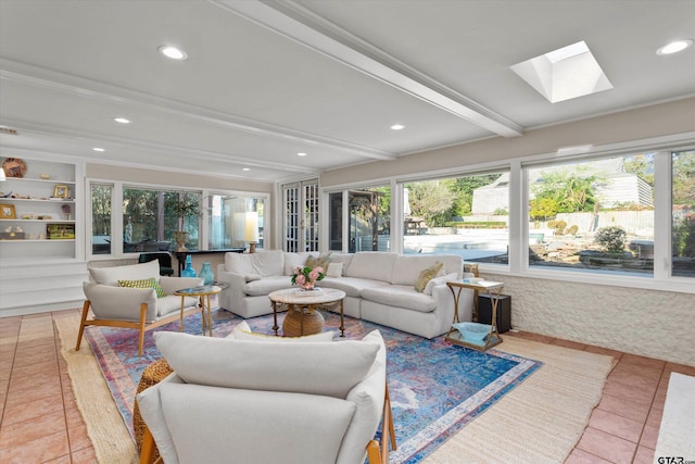 sunroom with beam ceiling and a skylight