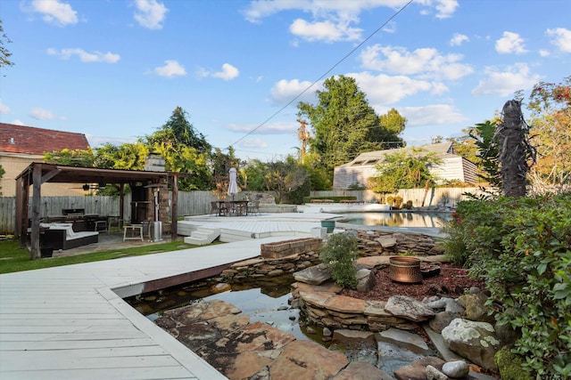 view of swimming pool with outdoor lounge area, ceiling fan, and a deck