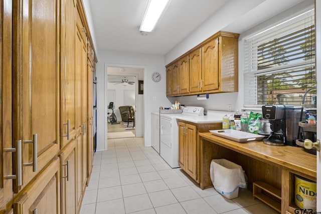 clothes washing area with washing machine and dryer, a ceiling fan, and light tile patterned floors