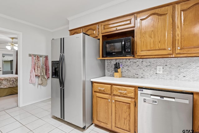 kitchen with backsplash, crown molding, stainless steel appliances, and light countertops