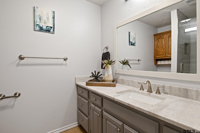 bathroom with a shower with shower door and vanity